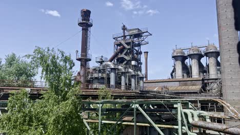 Hermosa-Foto-De-Un-Antiguo-Alto-Horno-De-Acero-Con-Instalaciones-Históricas-De-Fábrica-Con-Marcos-Crudos-Y-Metálicos-En-La-Naturaleza-Del-Parque-Paisajístico-En-Duisburg-Al-Norte-De-Alemania