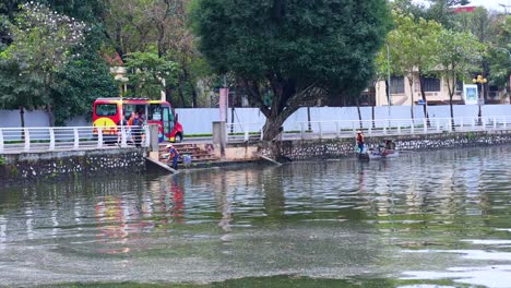 people in a boat collecting trash from water