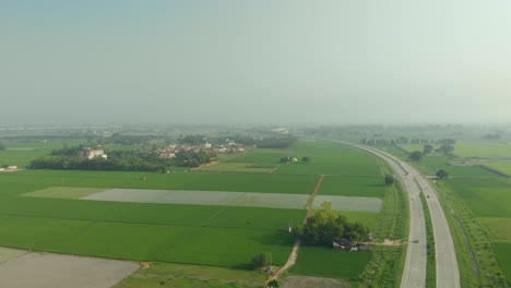 amazing aerial view of the well-organized agricultural land divided by the express highway in punjab province, india