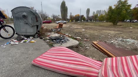 overfilled garbage bin and plastic rubbish bags causing environmental problem, static shot, couch, armchair at background