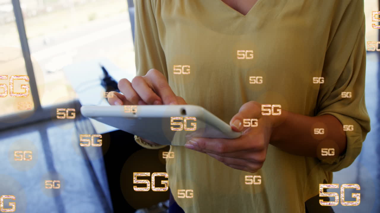 animación de múltiples textos 5g sobre la sección media de una mujer biracial de pie y usando una tableta digital