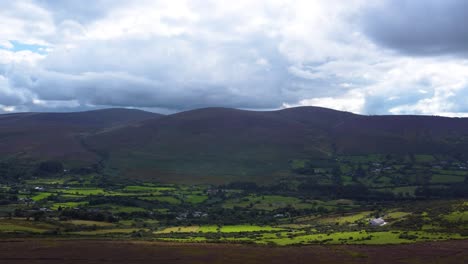 aerial fly-by over barren irish mountains and green pastures