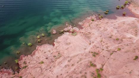 unique landscape scenery, drone aerial view of red sandstone coast and green lake water in sand hollow state park, utah usa