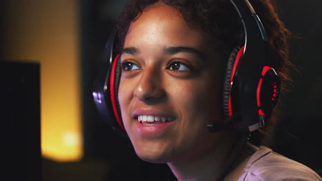 teenage girl wearing headset gaming online at home with friends