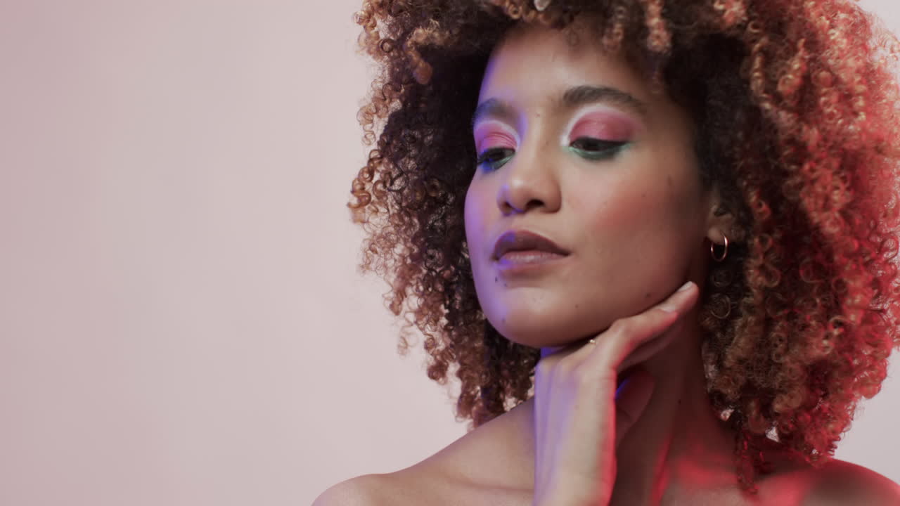 Donna meticcia con capelli scuri in luce blu e rosa con spazio per il testo, slow motion
