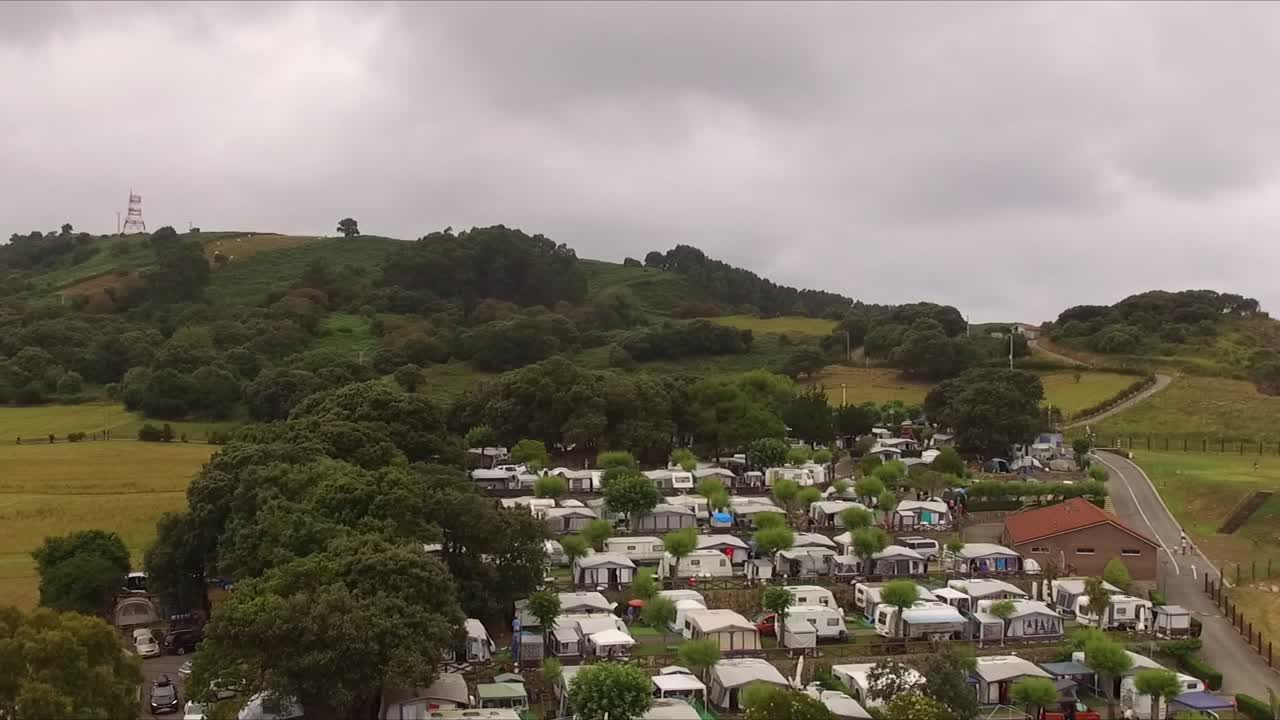 A camping site, playa de isla, with caravans and lush green landscape, aerial view