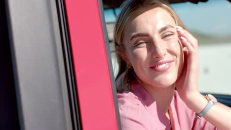 young caucasian woman smiles brightly in a car on a road trip, with copy space