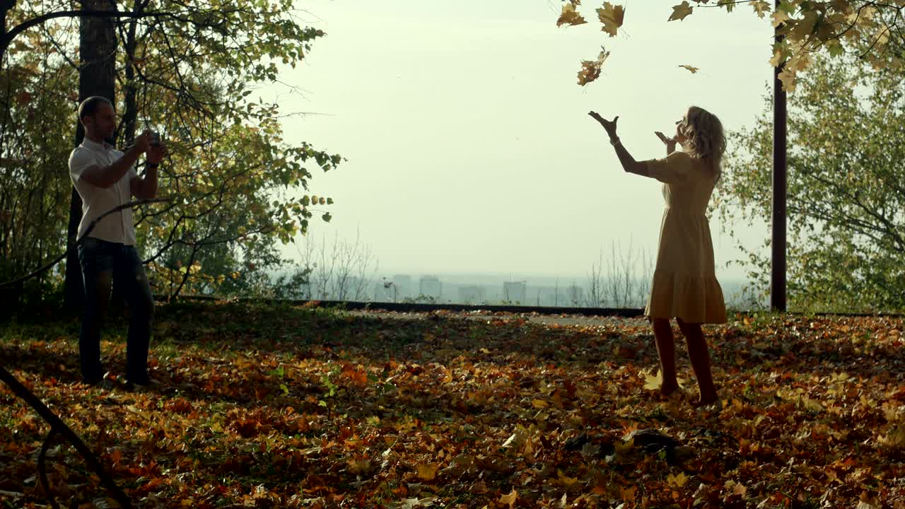 amantes con hojas de arce de otoño en el parque