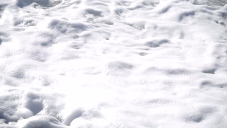 foamy ocean waves washing up on the pebble beach in greece