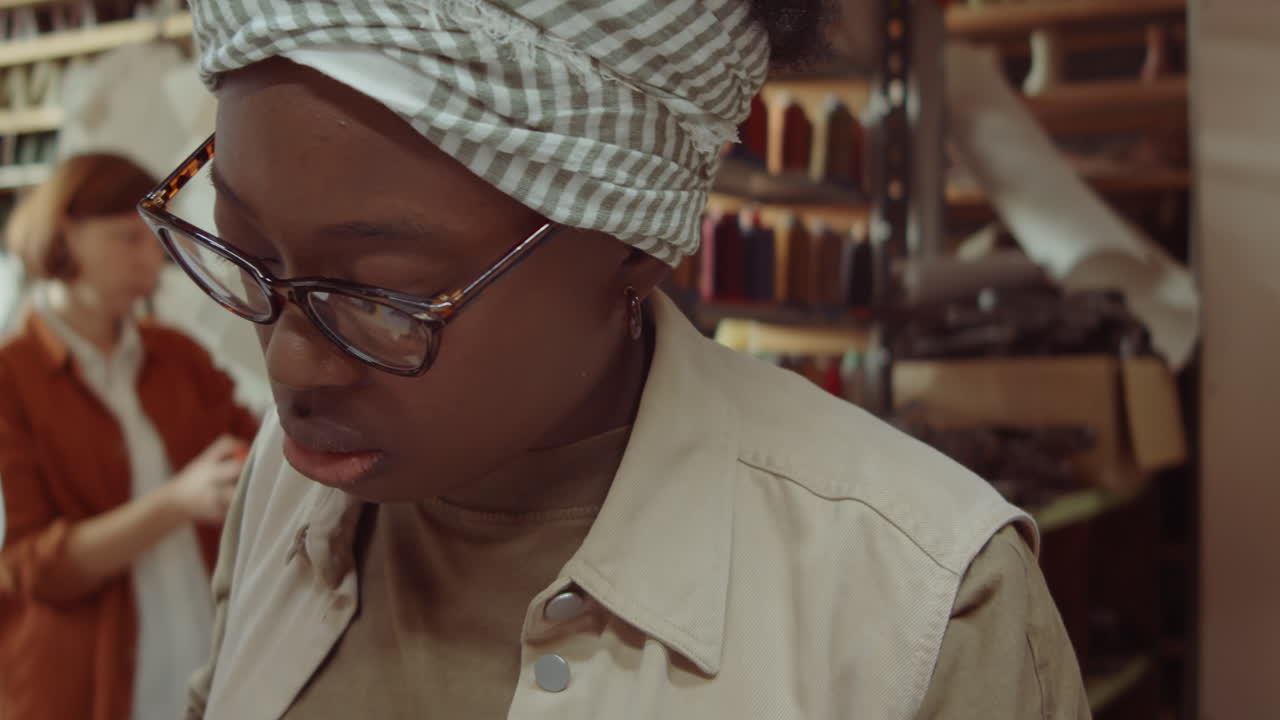 Afroameričanka řezající kůži v ševcovské dílně