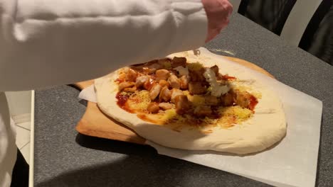 poniendo queso mozzarella y cebolla roja en la pizza