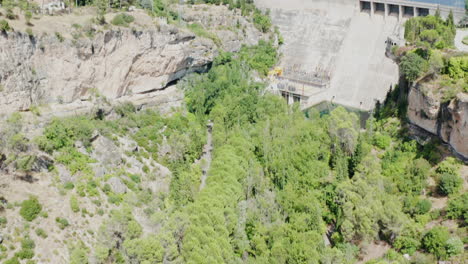 Toma-Aérea-Inclinada-Hacia-Arriba-De-Las-Montañas-Del-Pantano-De-Entrepenas,-El-Lago-Y-Una-Represa