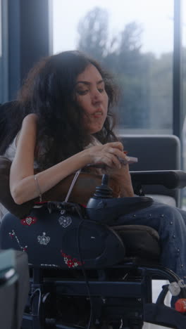 mujer en silla de ruedas usando un teléfono inteligente