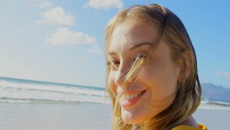 front view of young caucasian woman standing on the beach 4k