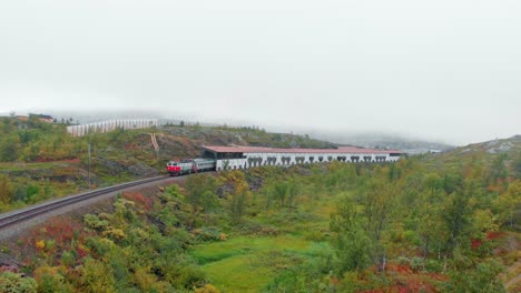 Aerial:-Sweden-arctic-train-emerging-from-a-tunnel-in-northern-Norway