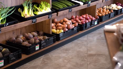 variety of vegetables in bins, for sale in market, slow pan, left to right.
