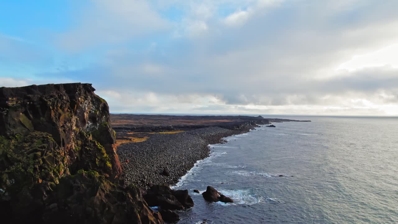 viajeros parados en la cima del acantilado islandés junto a la playa durante la hermosa puesta de sol