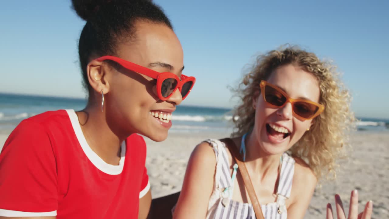 Two young adult female friends having fun at the beach 4k