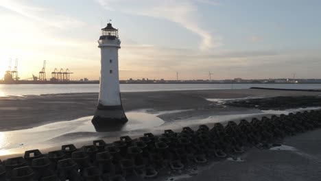 Luftaufnahme-über-Den-Britischen-Leuchtturm-Und-Die-Kräne-Der-Küstenwerft-Sunrise-Skyline-Niedrige-Umlaufbahn-Rechts