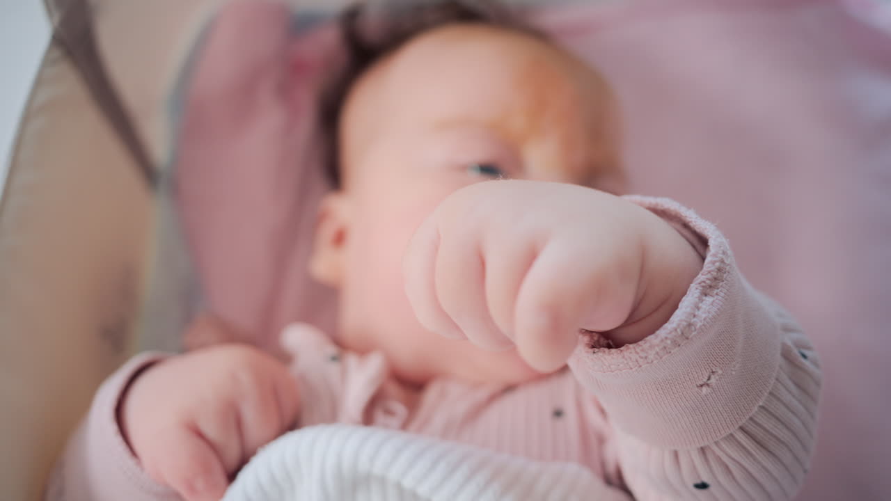 Close up of baby's tiny hand reaching out gently in soft pastel tones