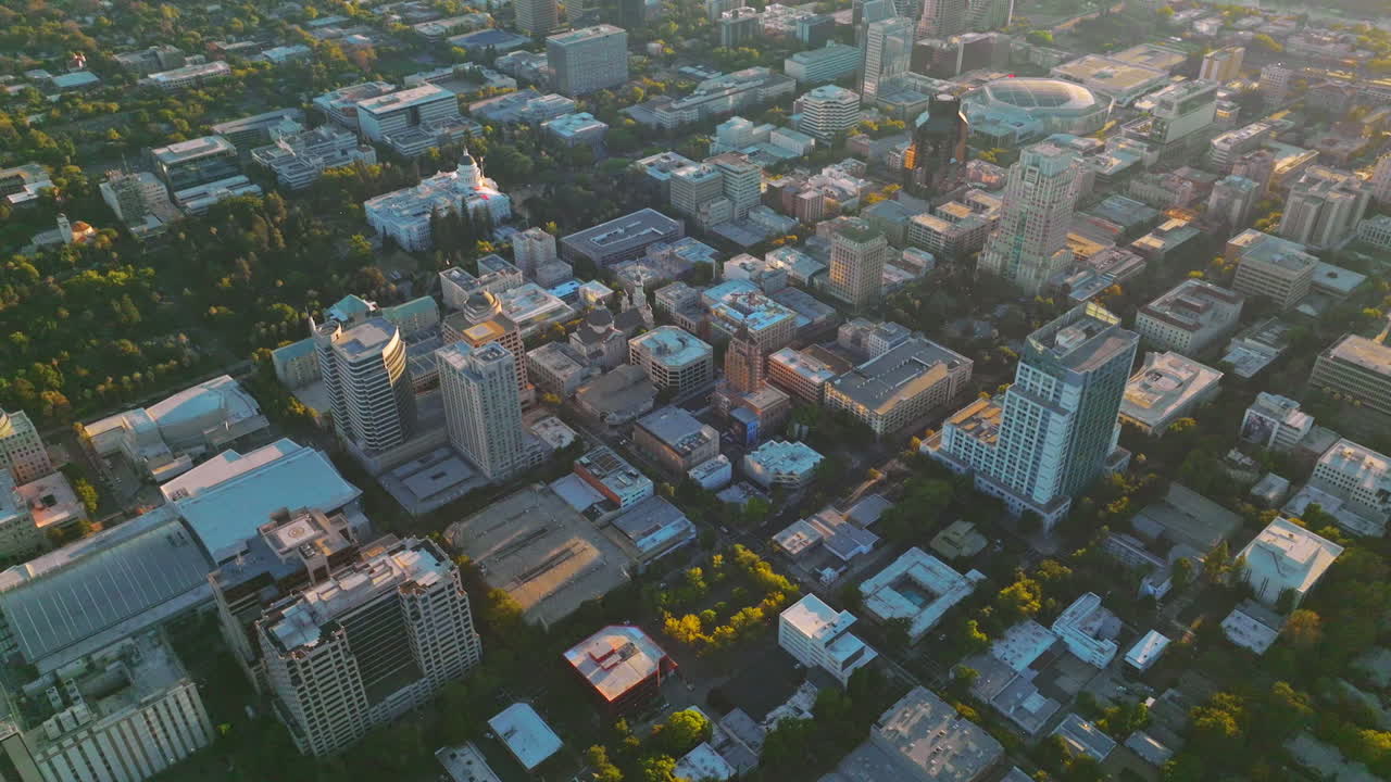 Sacramento city architecture full of greenery from aerial perspective. Drone footage over the city at sunset.