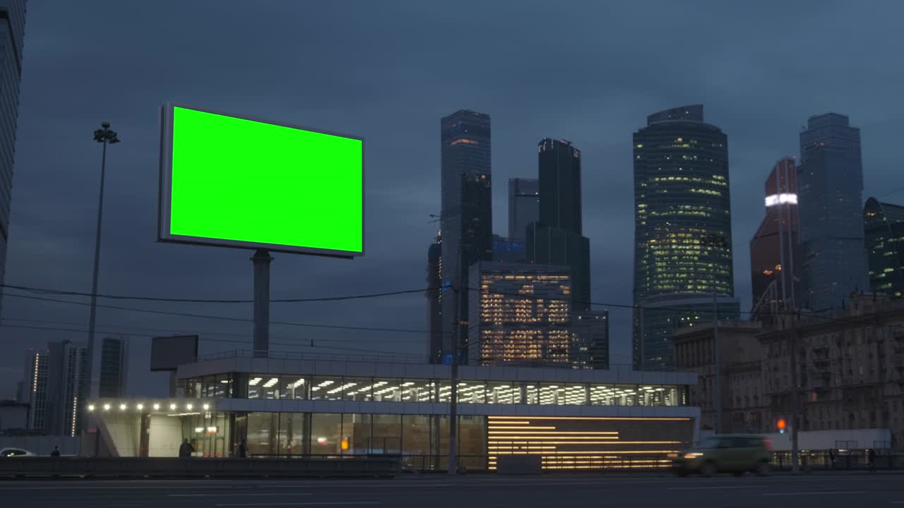 초록색 스크린 광고판 메가폴리스 고속도로에 네온 조명, 배경에 초고층 건물