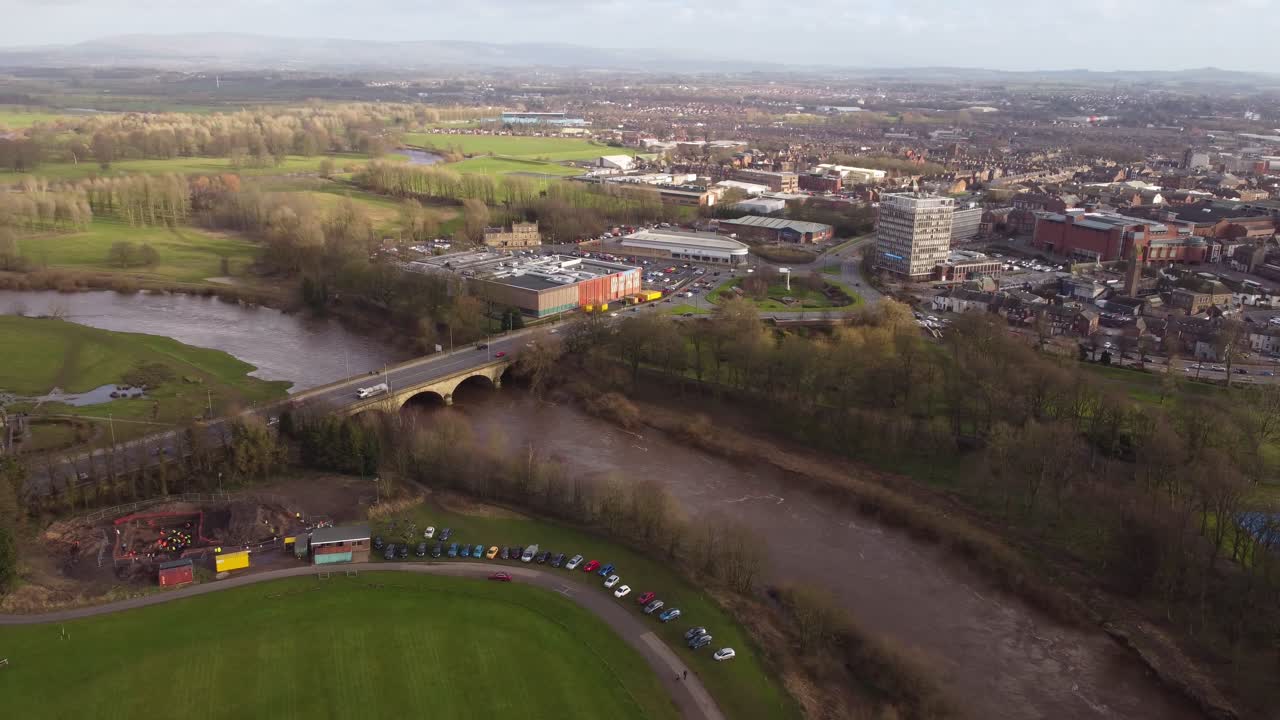Cinematic aerial view over Carlisle City and River Eden twisting through Rickerby Park - Cumbria, England