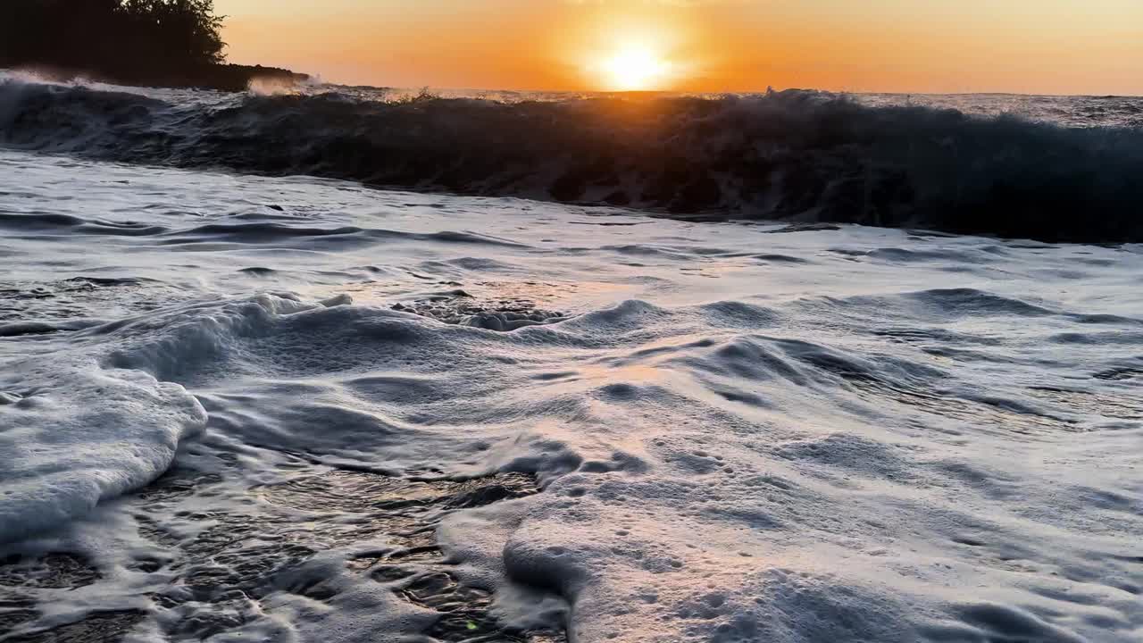 Meereswellen rollen bei Sonnenaufgang an den Kehena Beach auf Hawaii