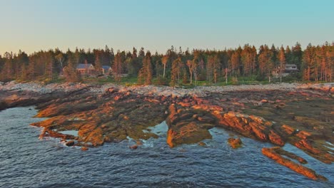 Golden-hour-sunlight-illuminates-the-shoreline-of-Newagen,-Cape-Harbor