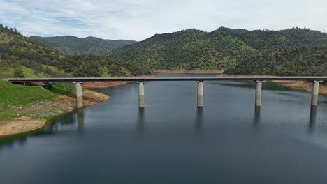 the don pedro reservoir bridge spans across the lake, seen from above in this aerial drone view. shot on a dji air 3s.