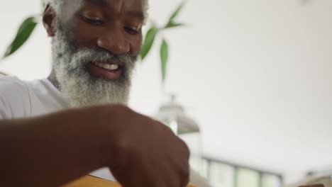 Video-of-sad-african-american-senior-man-playing-the-guitar