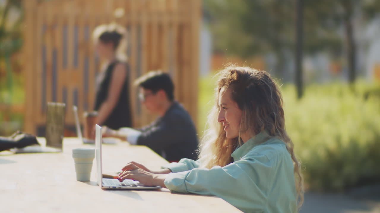 공원에서 원격으로 일하는 동안 노트북을 사용하는 여성