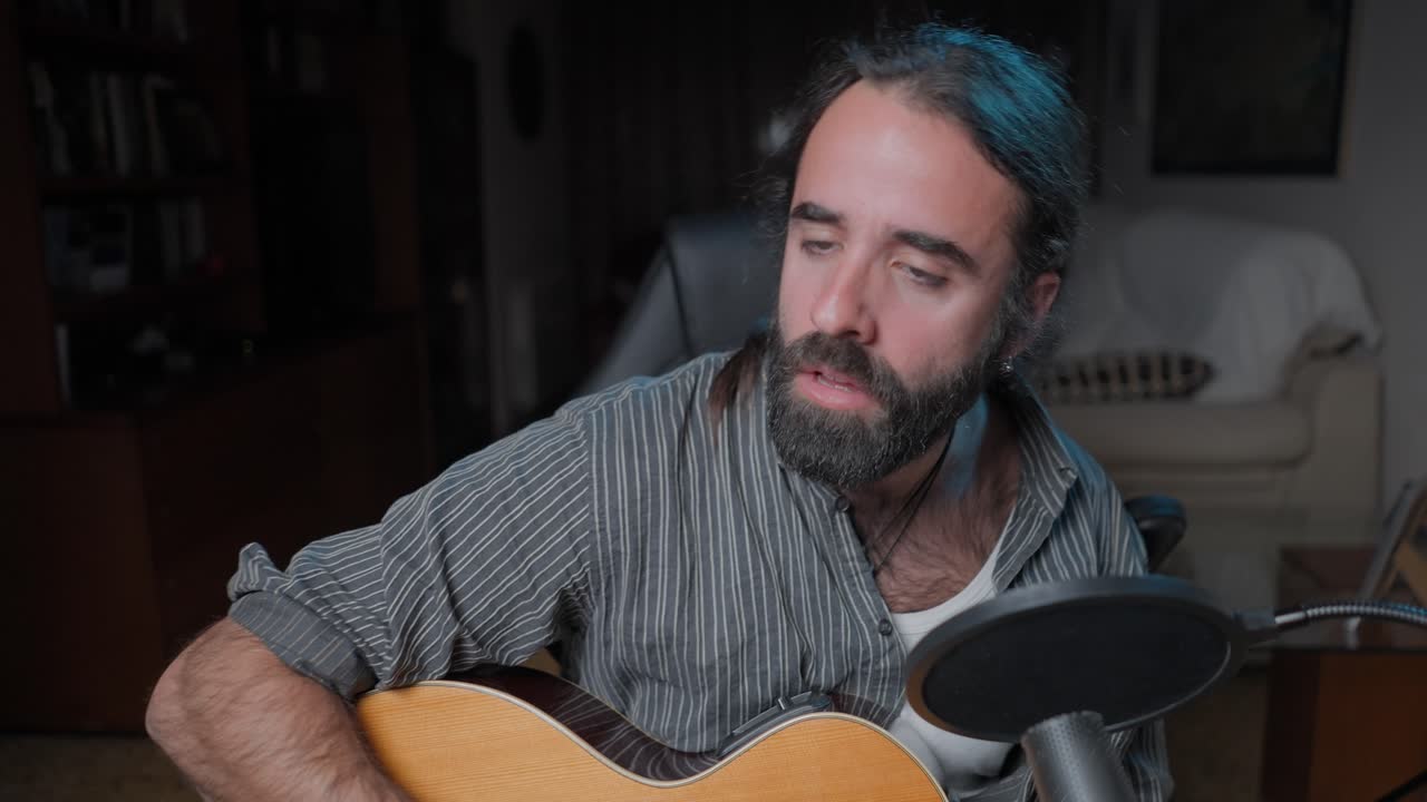 Man Playing Acoustic Guitar and Singing at Home