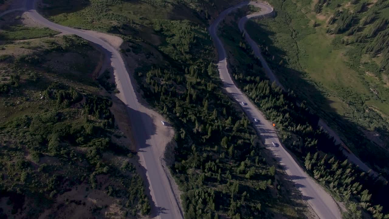 autos conduciendo alrededor de horquilla de alta elevación gire paso de montaña rocosa drone 4k