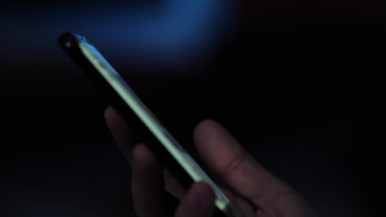 Woman hand using smartphone with lights bokeh.