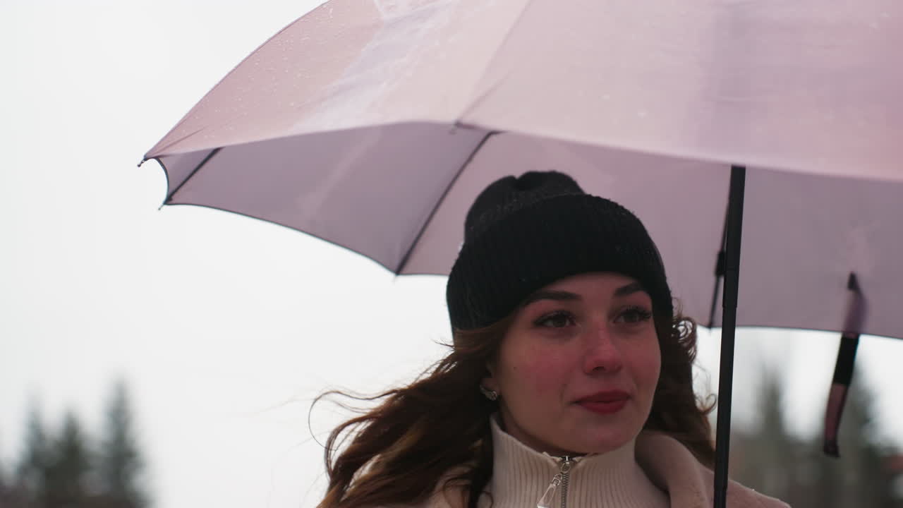 Close shot of thoughtful girl running in light snowfall holding umbrella wearing knit cap brown shearling jacket, cold weather, serene atmosphere, winter scene, casual outdoor style, snowy day