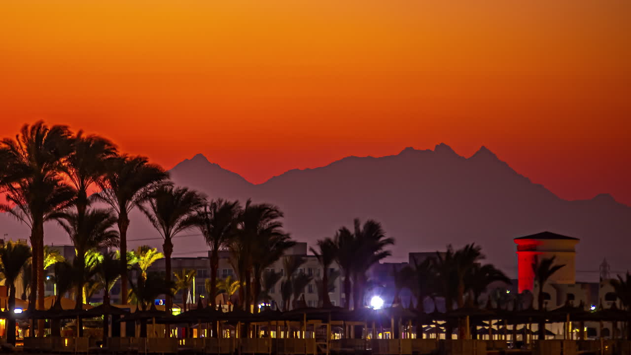 주황색 하늘이 있는 일몰의 파티오로 가득한 해변