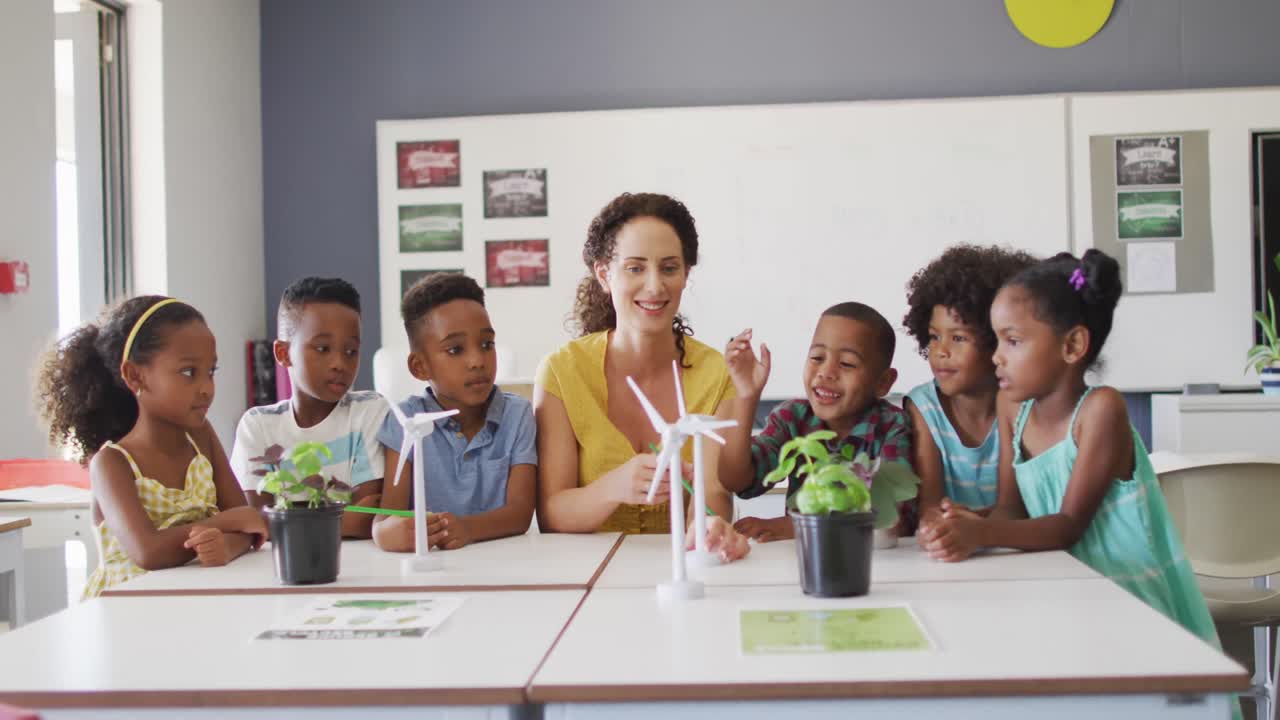 Video of happy caucasian female teacher and class of diverse pupils studying ecology in classroom