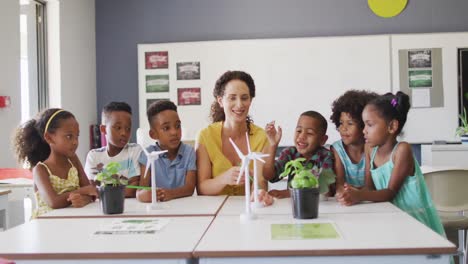 Video-Einer-Glücklichen-Kaukasischen-Lehrerin-Und-Einer-Klasse-Verschiedener-Schüler,-Die-Im-Klassenzimmer-Ökologie-Studieren