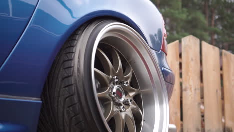 blue car in puddle with modified wheels