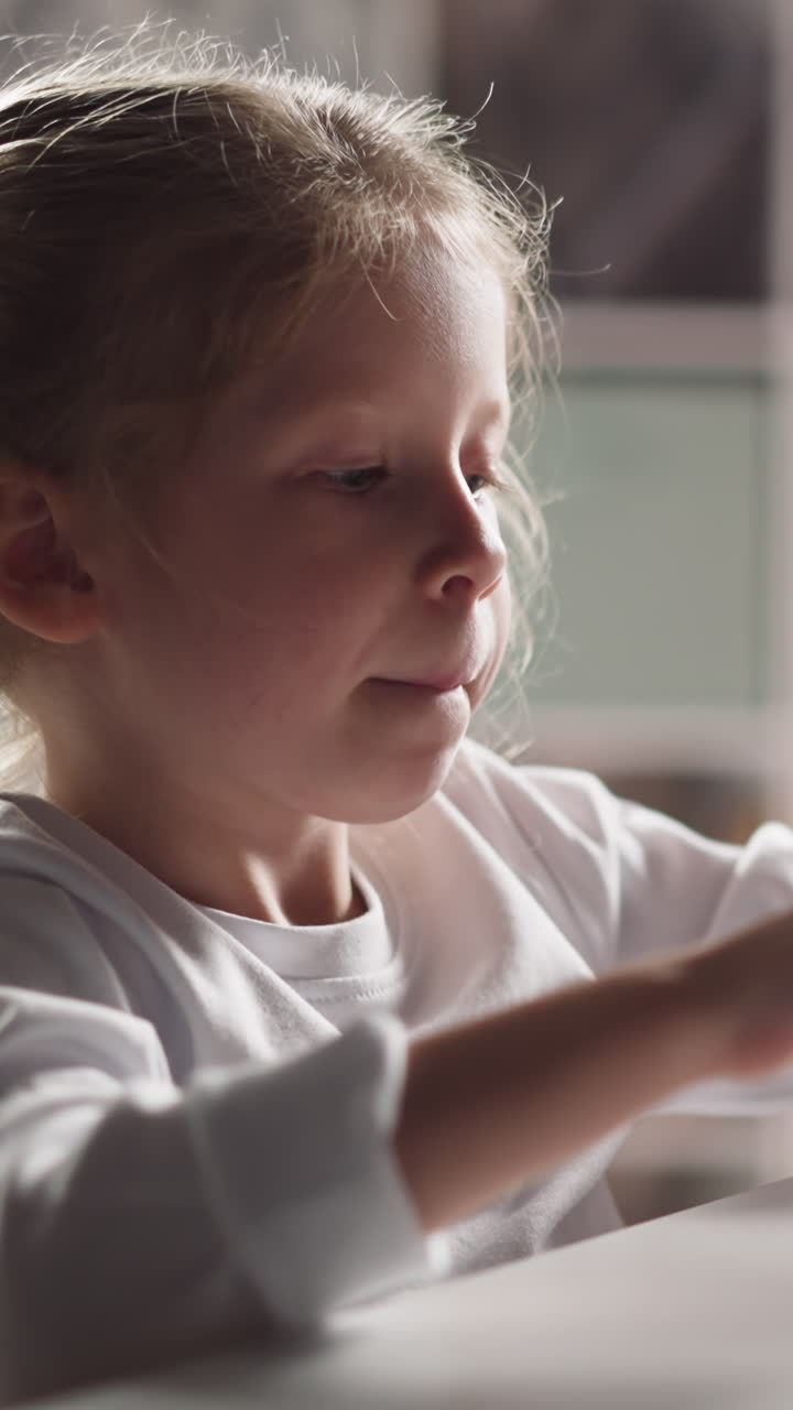 Funny little girl with braids stretches arms and puts tongue out preparing to count colorful sticks at mental arithmetic lesson closeup slow motion
