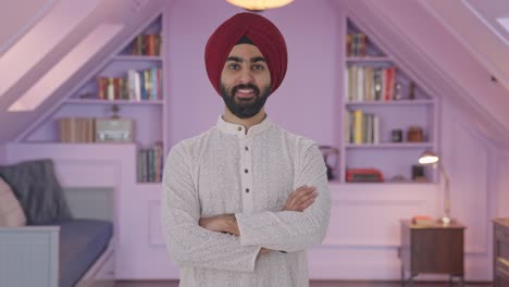 hombre indio sikh feliz de pie con las manos cruzadas