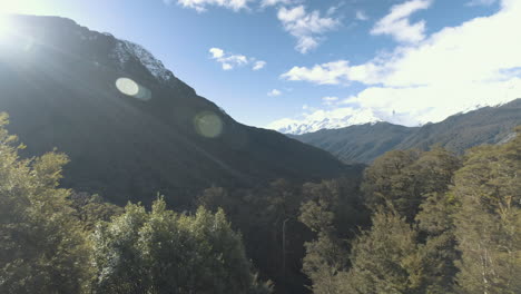 toma panorámica de montañas cubiertas de nieve y exuberantes bosques y valles verdes en un día soleado en nueva zelanda