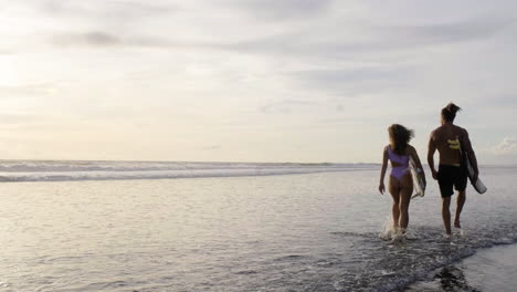 young couple with surfboards