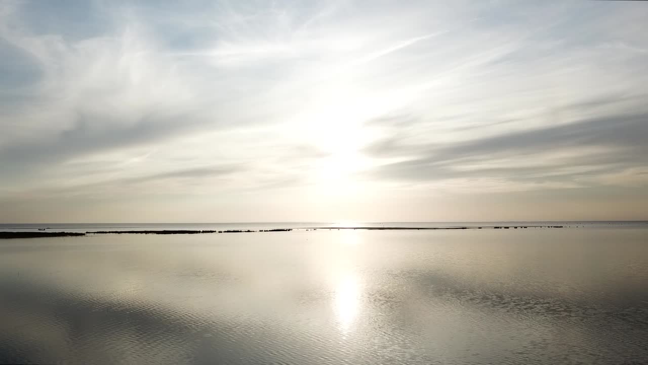 바람 없는 날 에스토니아에서 평평한 발트해 위로 빛나는 태양이 거울 같은 효과를 만들어냅니다.