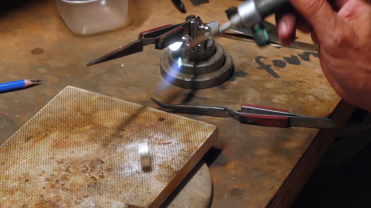 artesana elaborando un anillo con un soplete