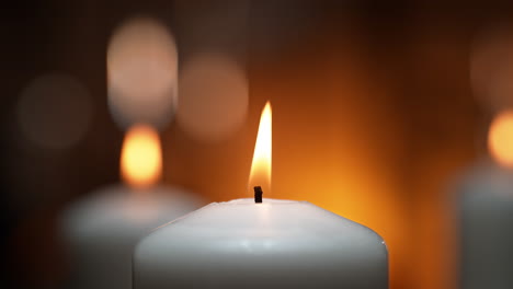 flames of white ceremonial candles dancing in a tranquil spa atmosphere in slow motion