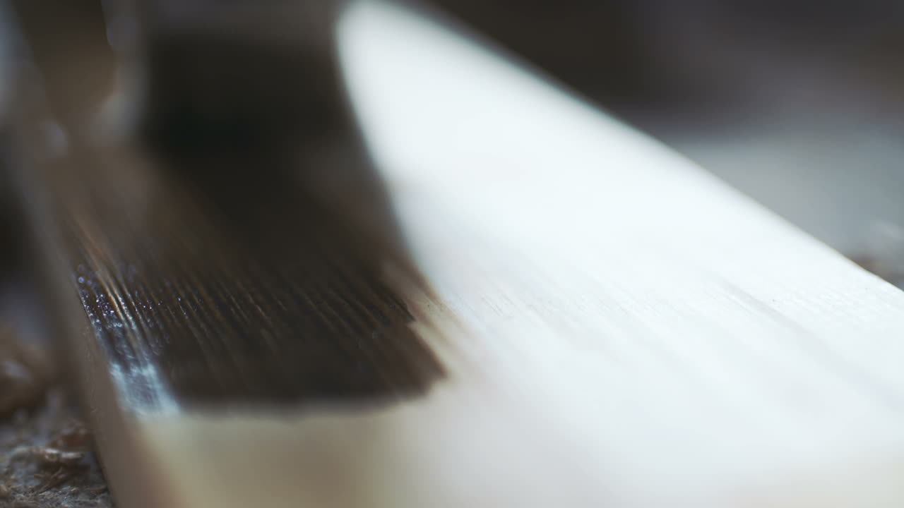 갈색 페인트로 나무 판자를 칠하는 청년 3