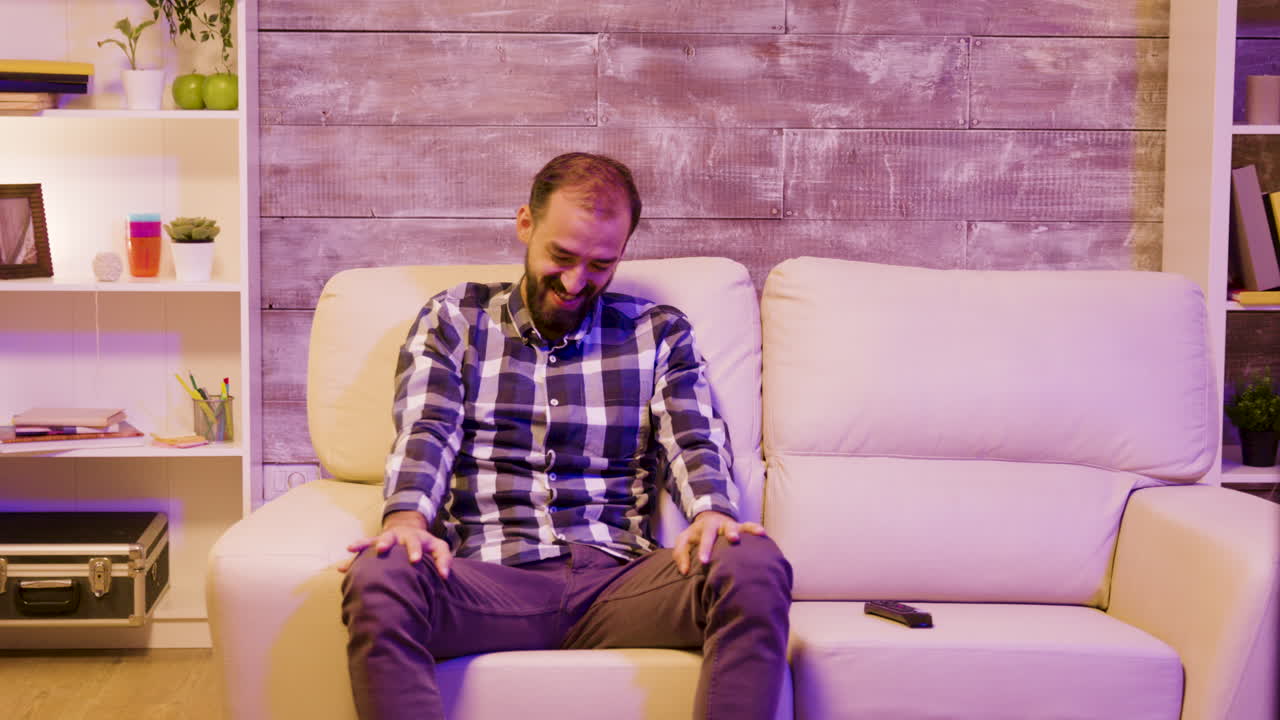 Man sitting on couch watching television