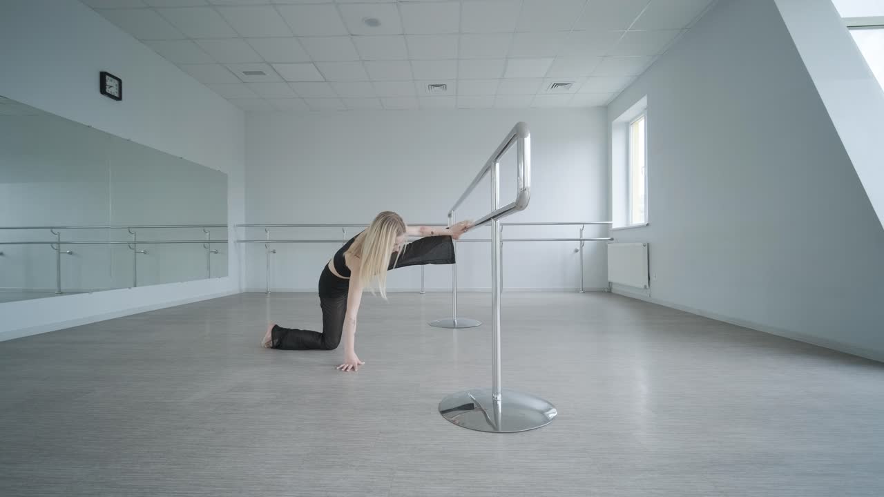 흑색 옷을 입은 소녀가 동시대를 선보이며, 여성 댄서가 하 방에서 흐르는 움직임, 몸과 손의 파동을 보여줍니다. 현대 발레 댄스 안무. 젊은 여성이 부드럽게 움직이고 있습니다.